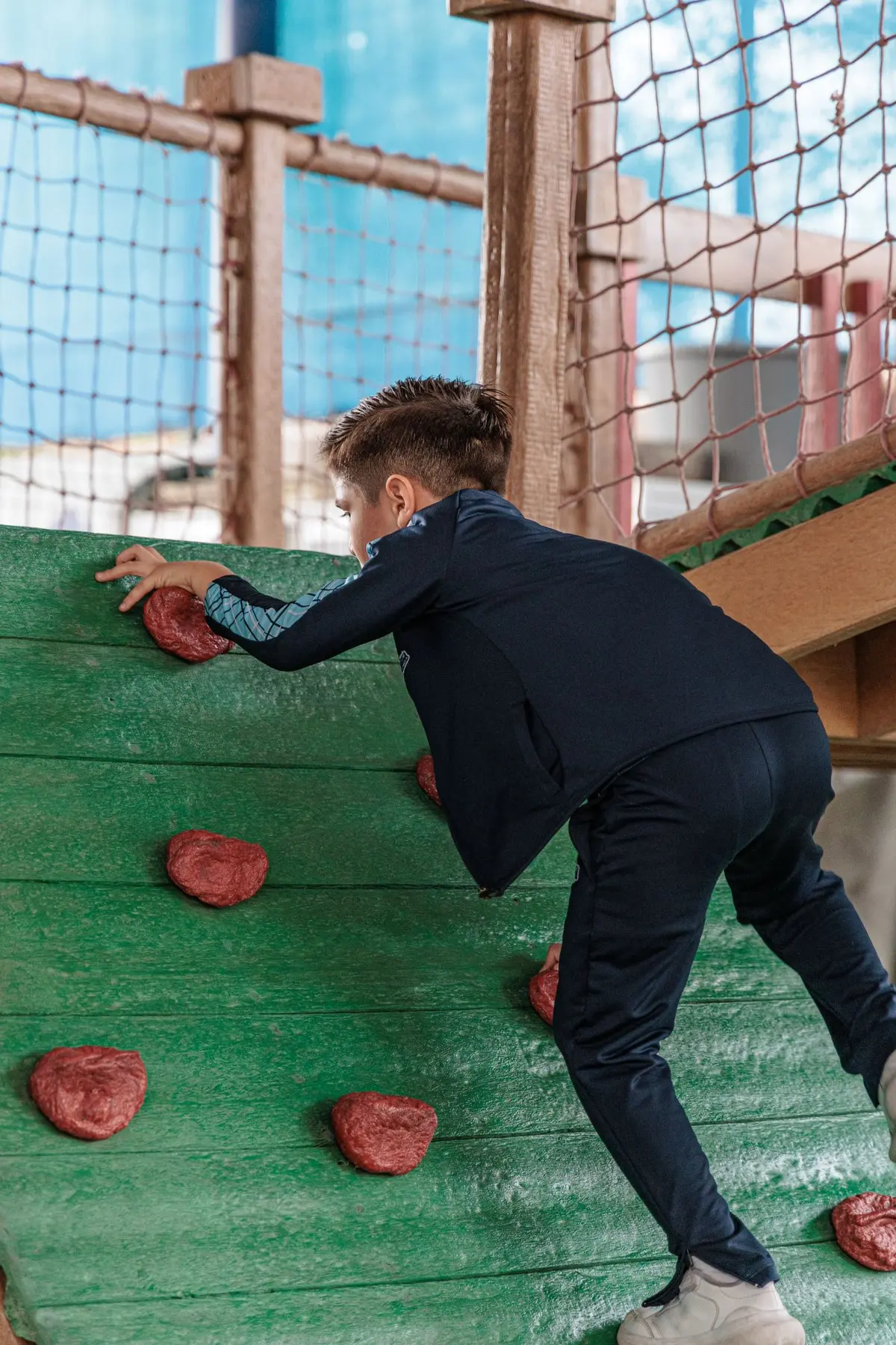 Alumno escalando el muro del área de juegos del Campus Melitón